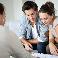 couple sitting at a table and looking at plans with their designer